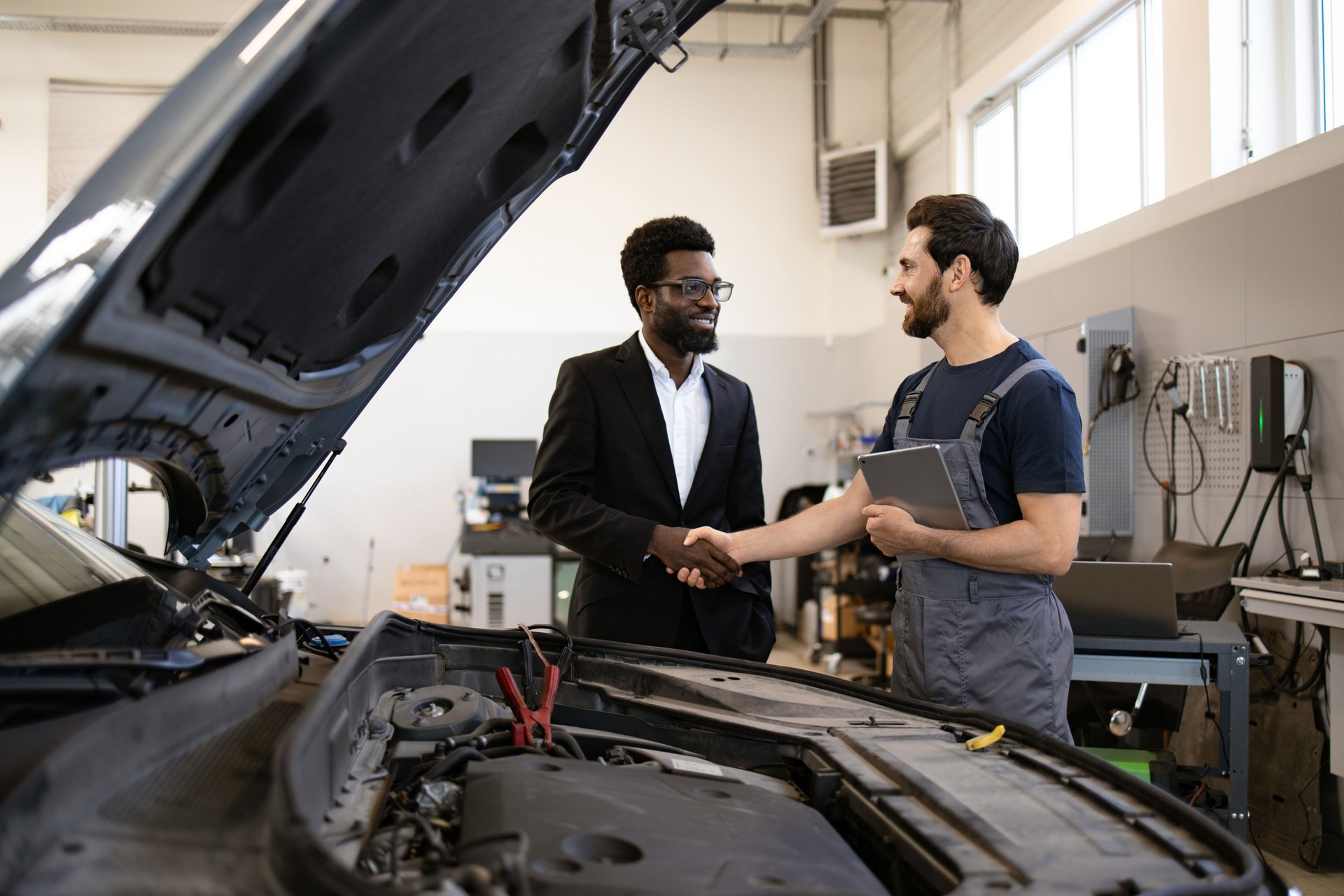 Mechanic shaking hands with customer at auto repair shop