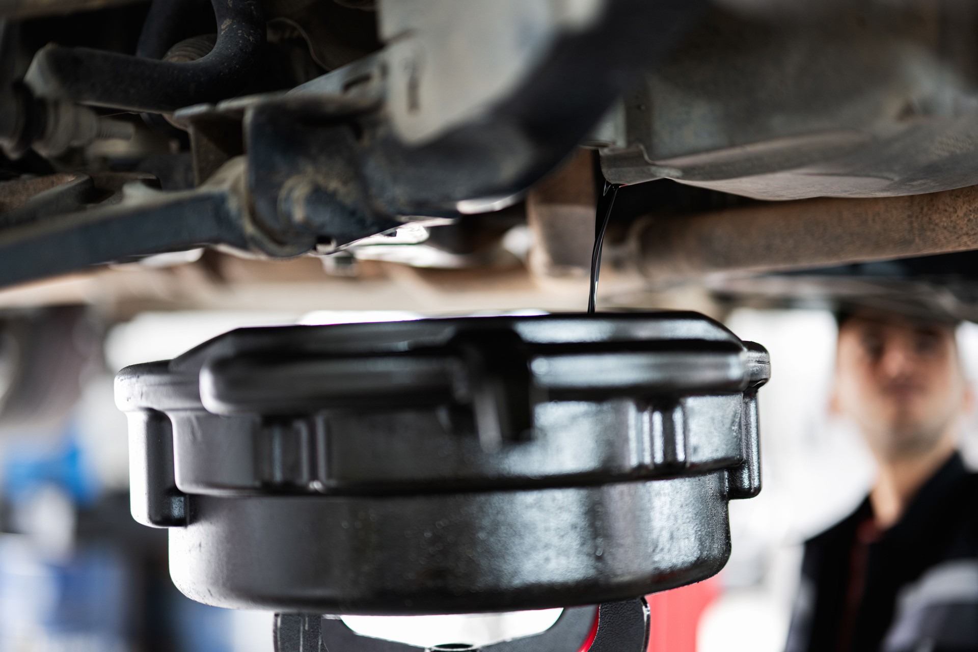 Mechanic performing an oil change in an auto repair shop